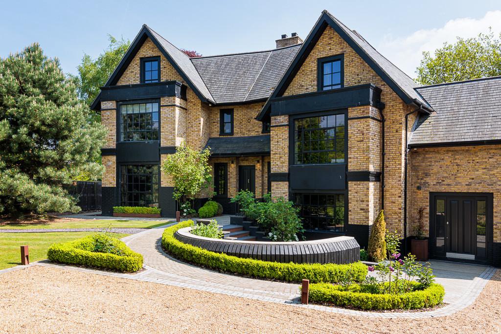Front facade of The Ponds showing mellow brick exterior, deep square bays and formal parterre garden