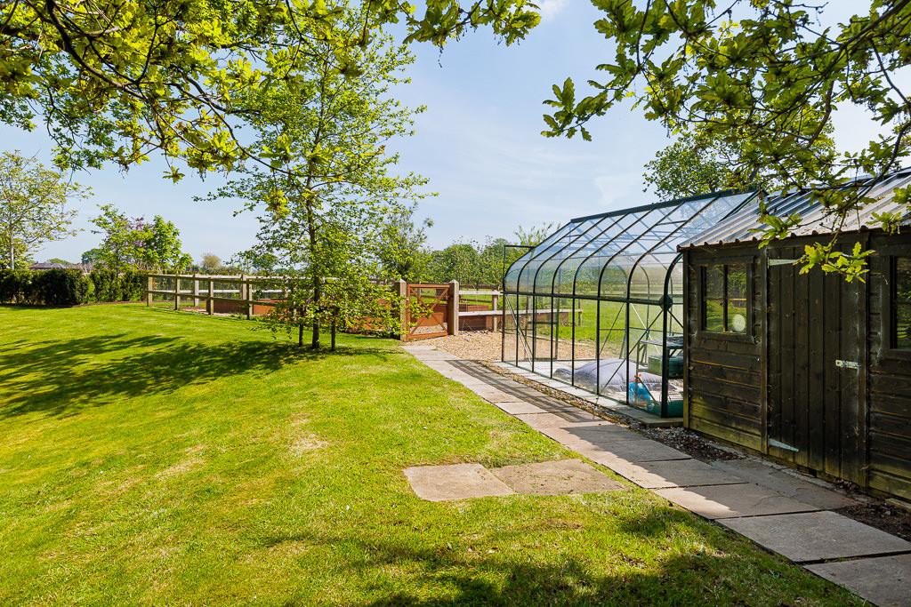 Well-maintained greenhouse and raised vegetable beds