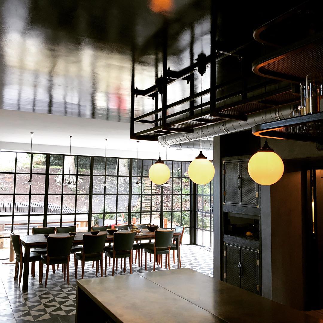 Kitchen dining room with dark lacquered ceiling, globe pendants and Crittall windows