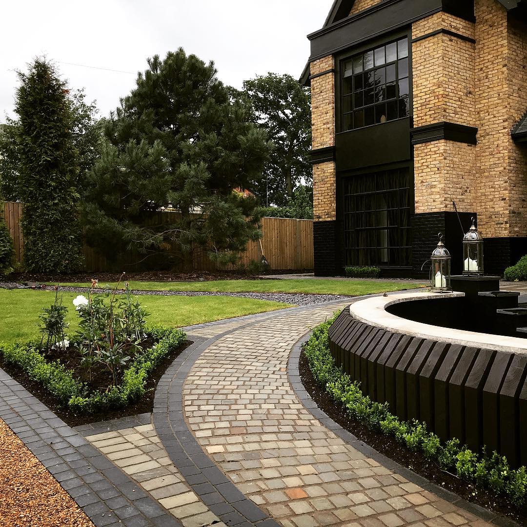 Front garden with curved block-paved driveway and circular water feature