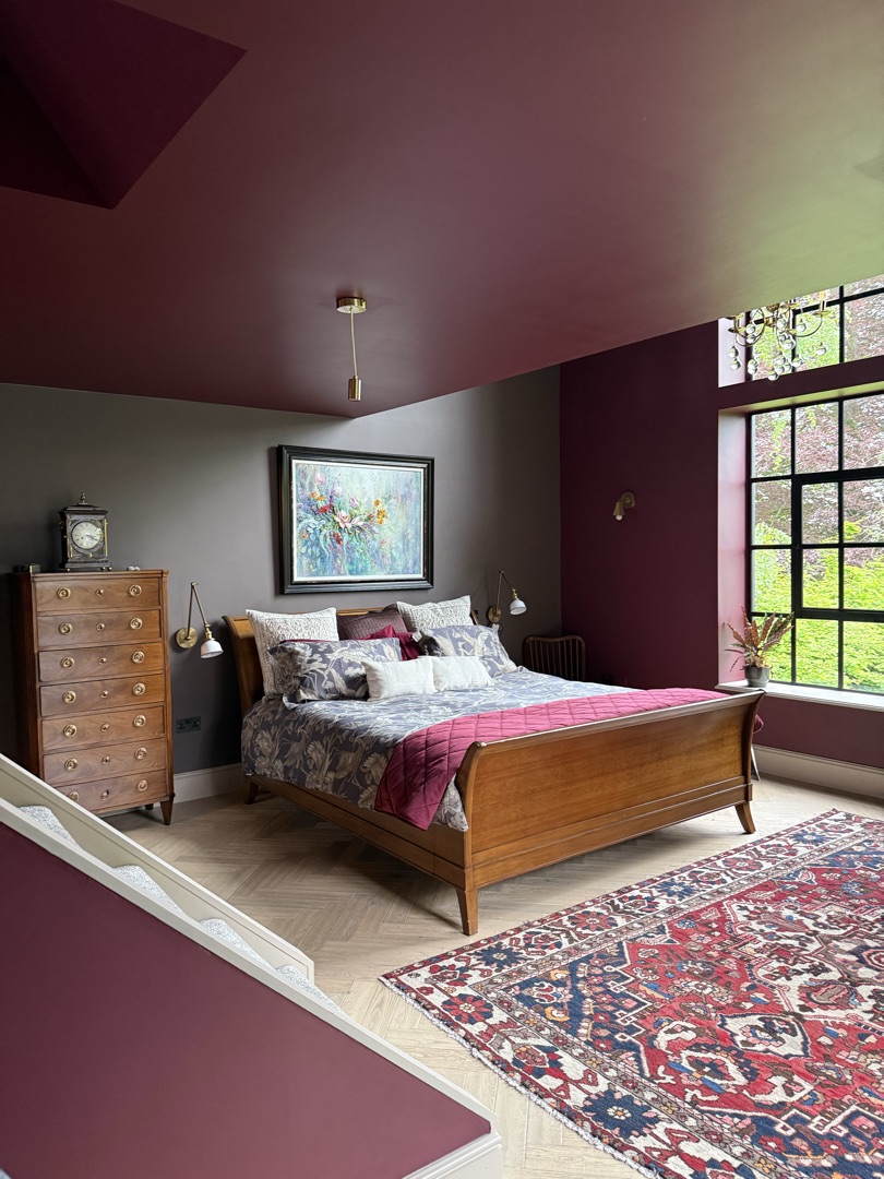 The Ponds Goostrey — burgundy bedroom with sleigh bed, antique chest of drawers and Crittall window to garden