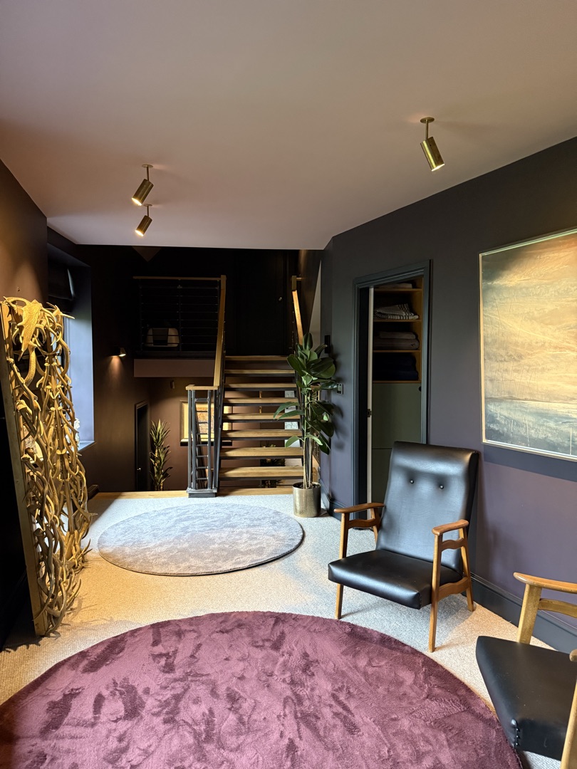 The Ponds Goostrey — upper landing with steel and oak staircase, leather chair, sculptural artwork and linen storage cupboard