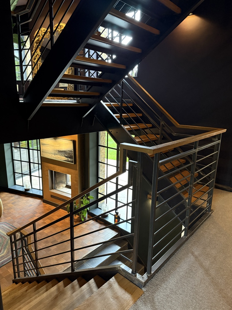 The Ponds Goostrey — elevated view of the modern oak and steel-framed staircase with herringbone parquet below
