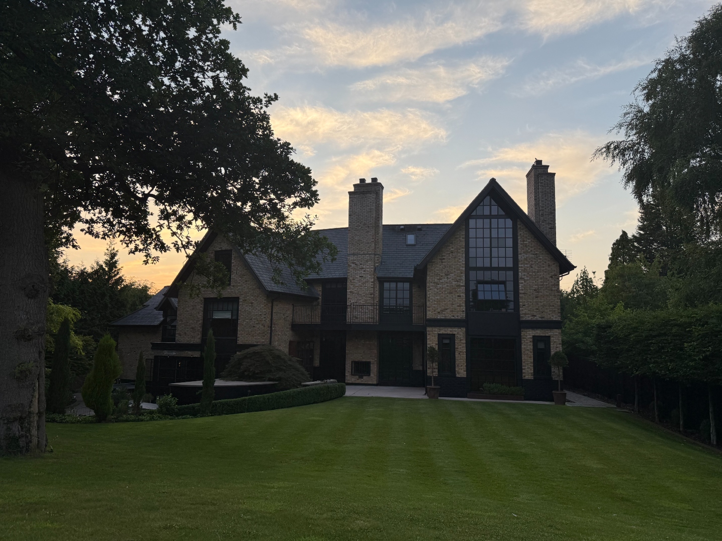 Rear elevation at sunset viewed across the striped lawn