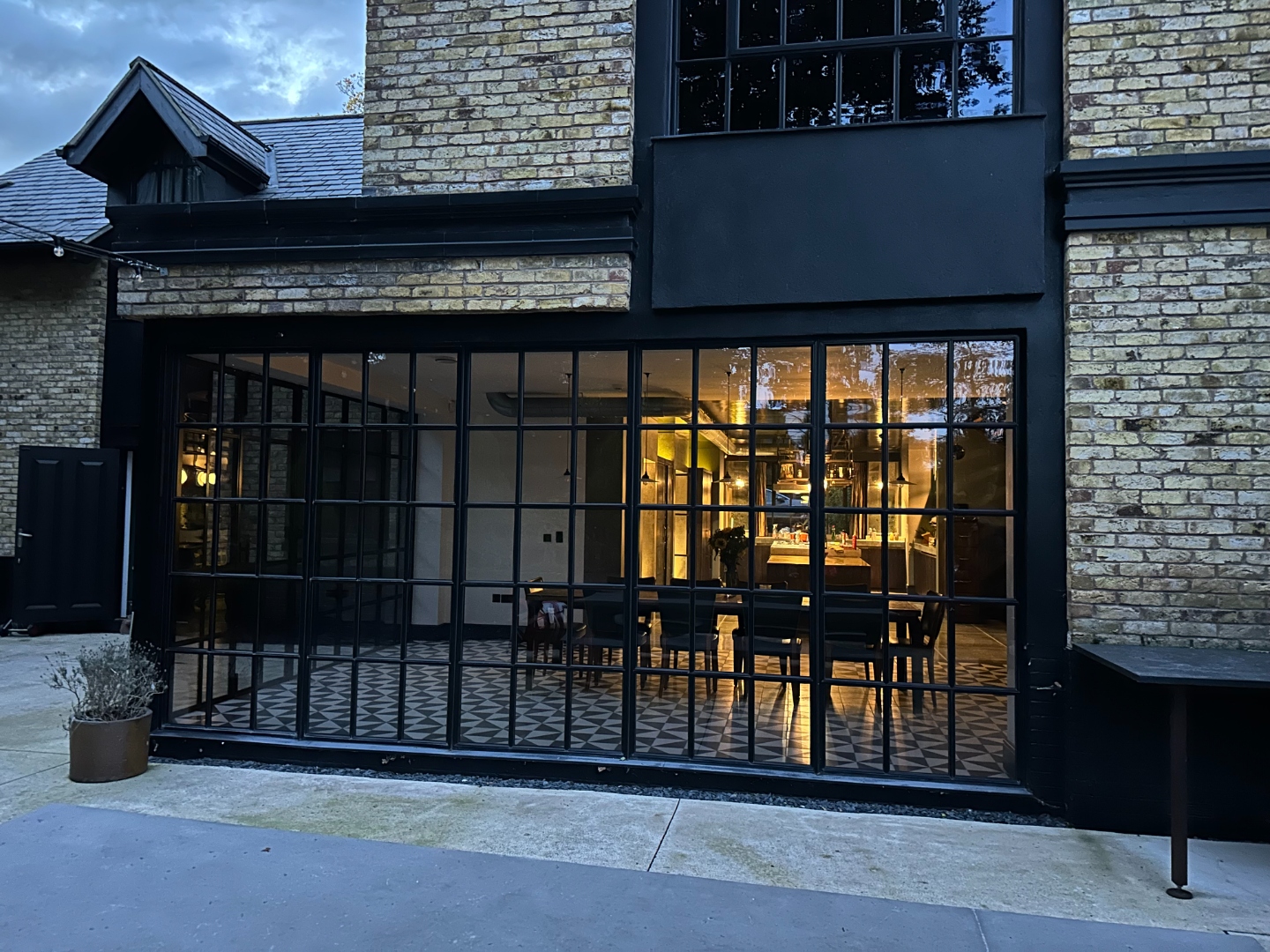 Crittall kitchen window illuminated at dusk, view into the kitchen