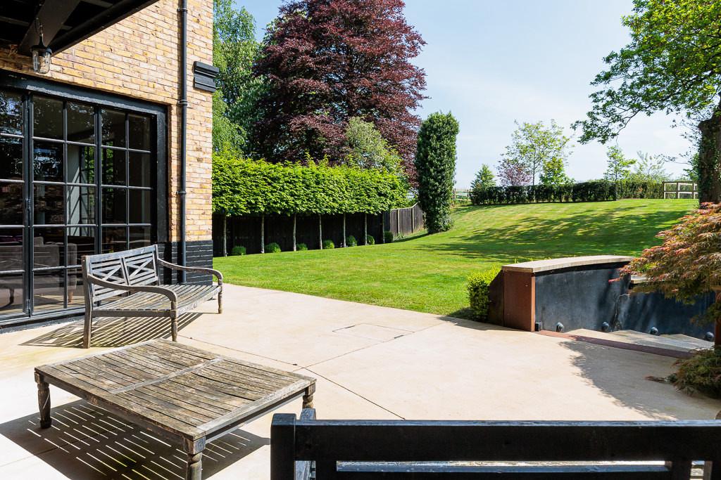 Rear terrace with mature planting and access to the garden